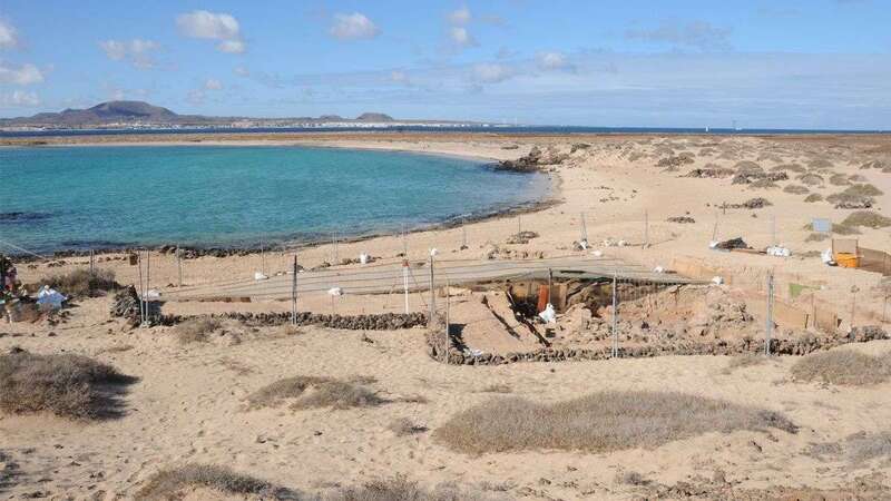 Playa de Las Conchas, en el sur del Islote de Lobos. En primer plano, parte del yacimiento que alberga un taller de púrpura de factura romana; al fondo, la isla de Fuerteventura/CA.